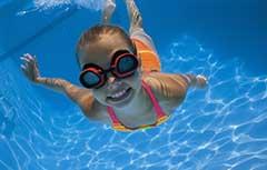 Young girl in goggles swimming